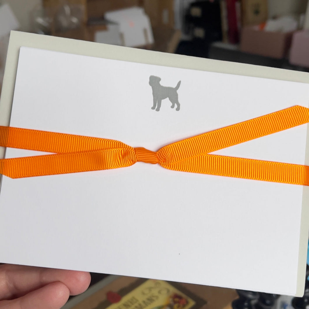 Border terrier image at the top of the white card and  wrapped with an orange grosgrain ribbon