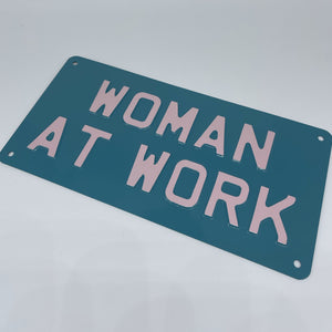 Woman At Work metal sign, teal and baby pink 